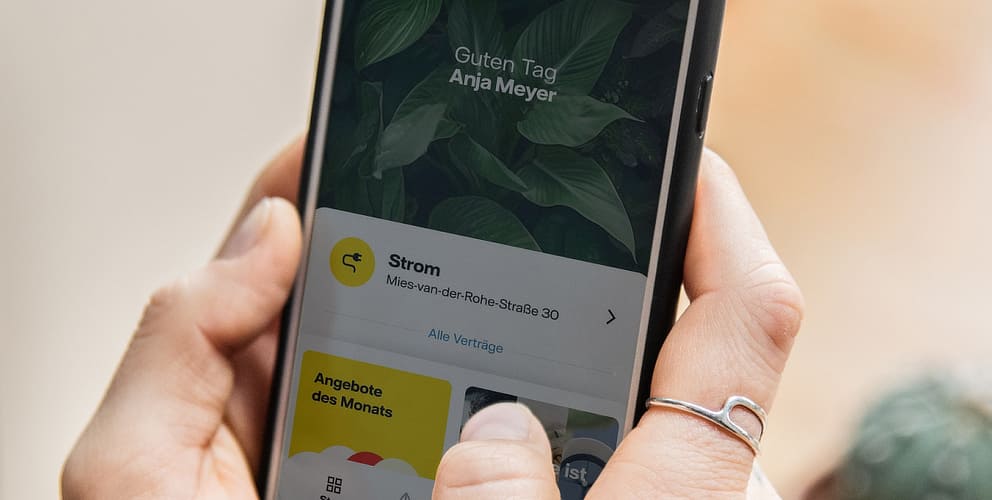 Hand hält Smartphone. Auf dem Bildschirm ist die geöffnete Vattenfall-App zu erkennen.
